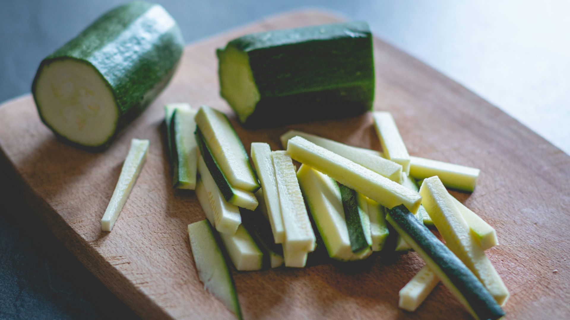 sliced green vegetable on brown wooden chopping board