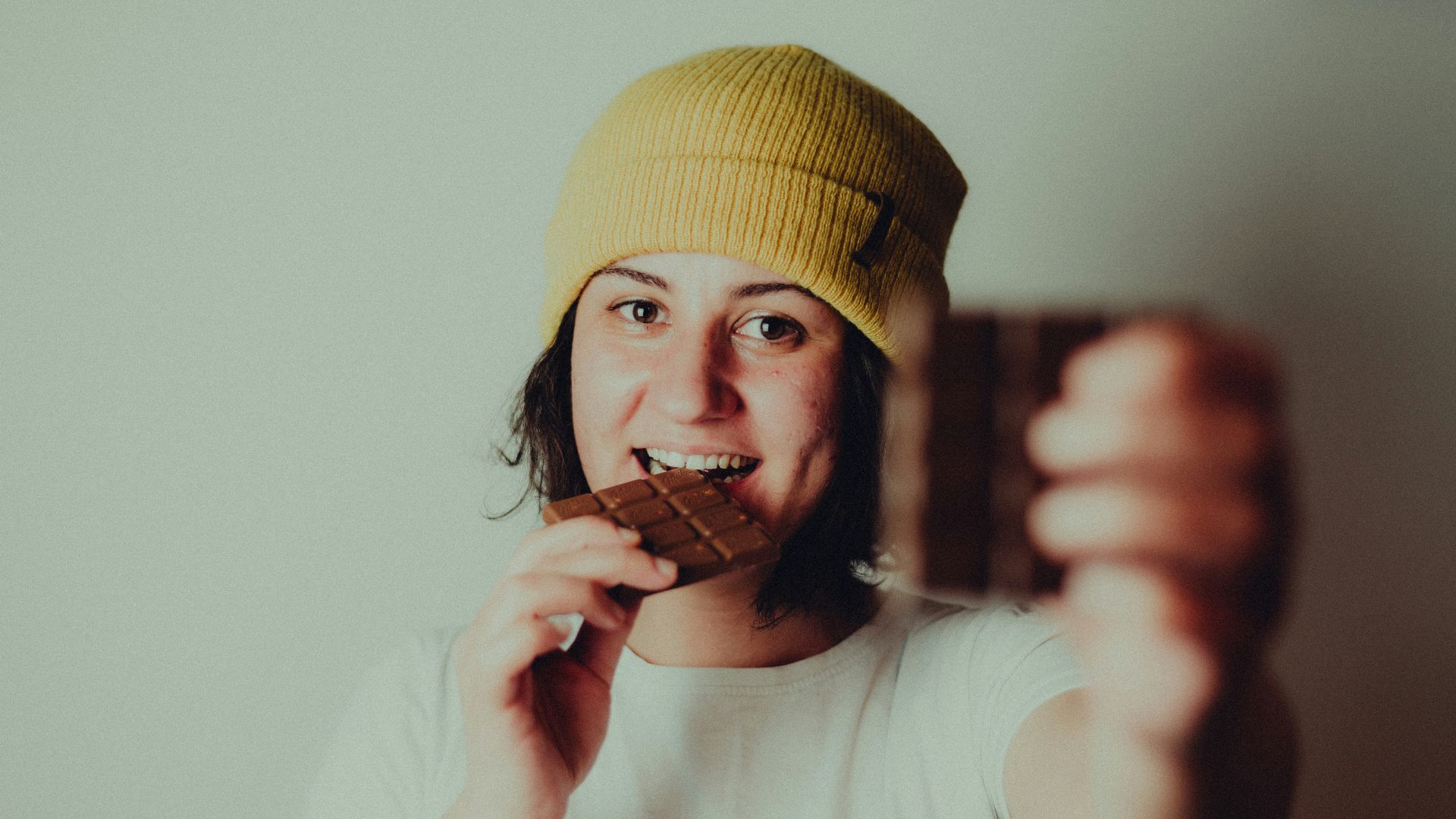 woman in white crew neck t-shirt wearing yellow knit cap