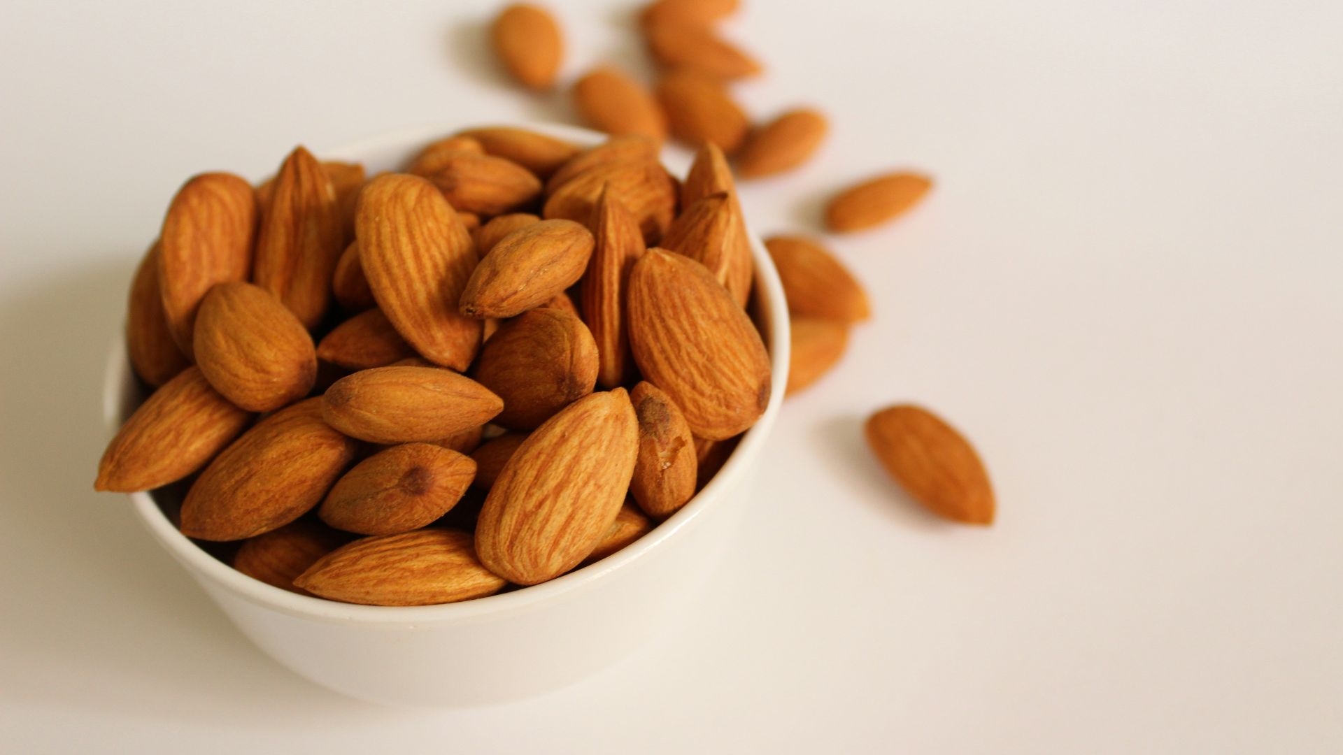 brown almond nuts on white ceramic bowl