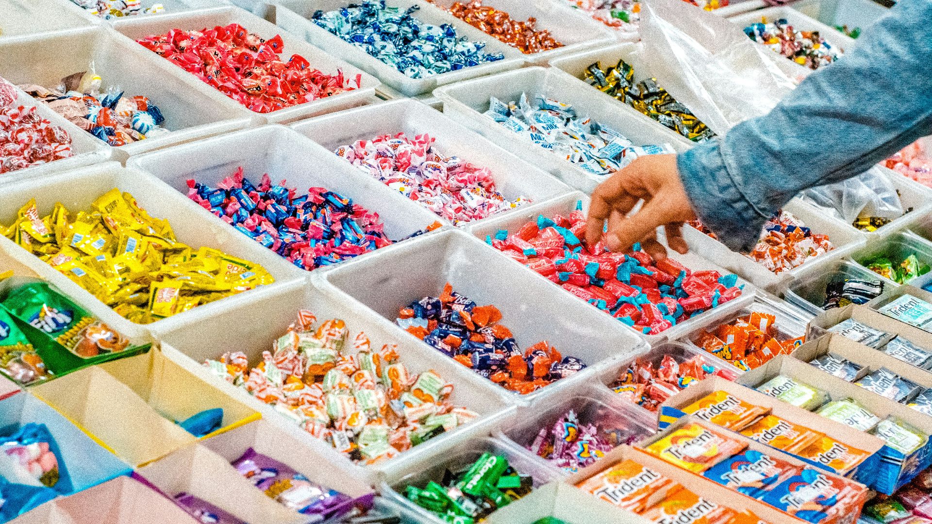 person holding a candy pack on white plastic box