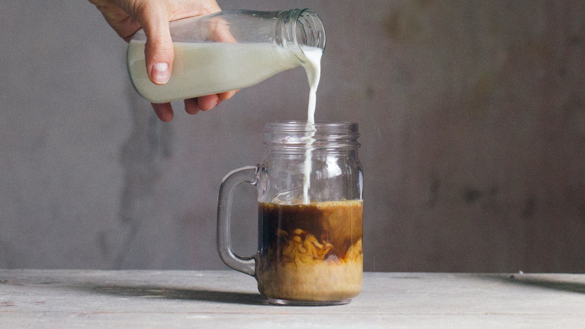 person filling milk on glass