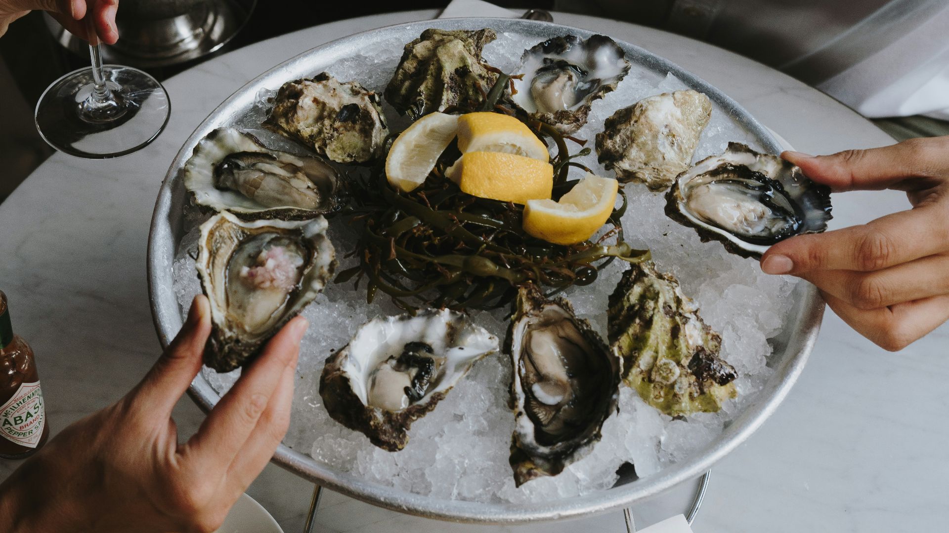 a table topped with oysters and wine glasses