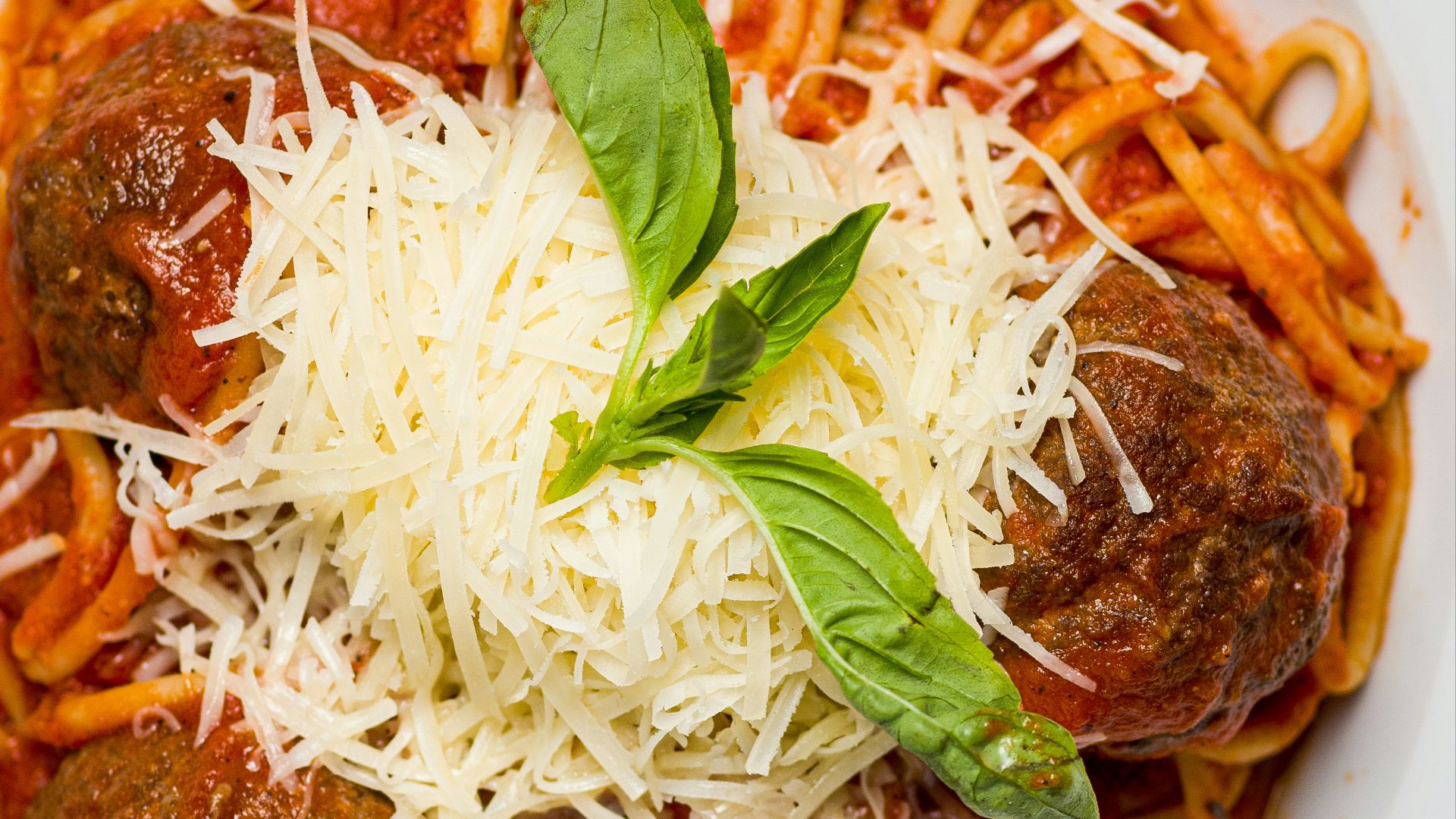 a white plate topped with spaghetti and meatballs