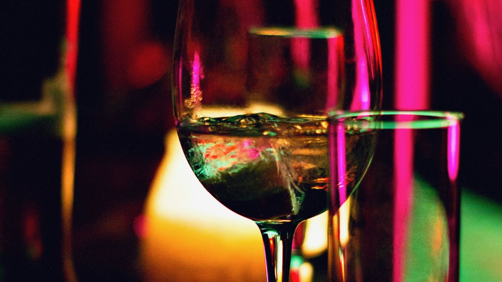 half filled wine glass beside half empty clear pint glass