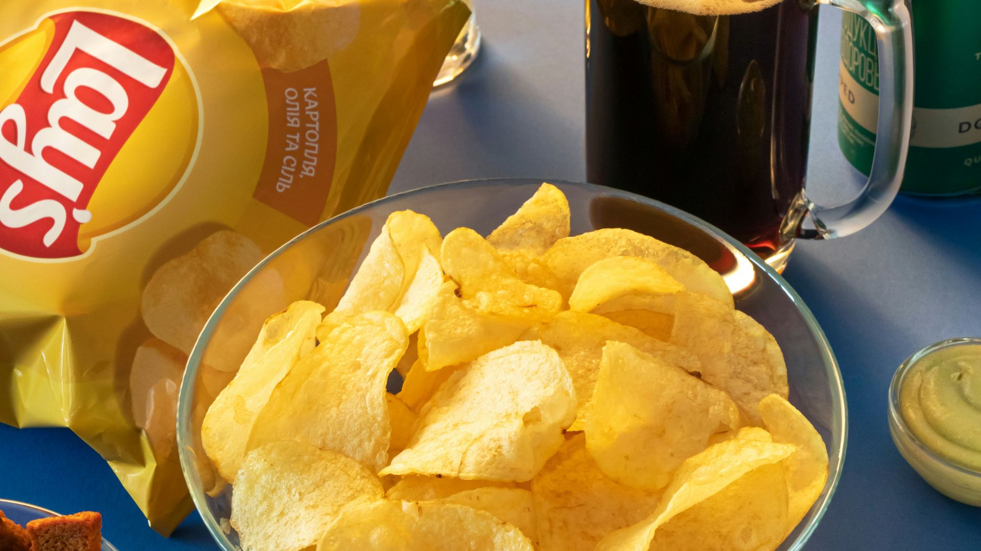 clear drinking glass beside brown bread on blue ceramic plate