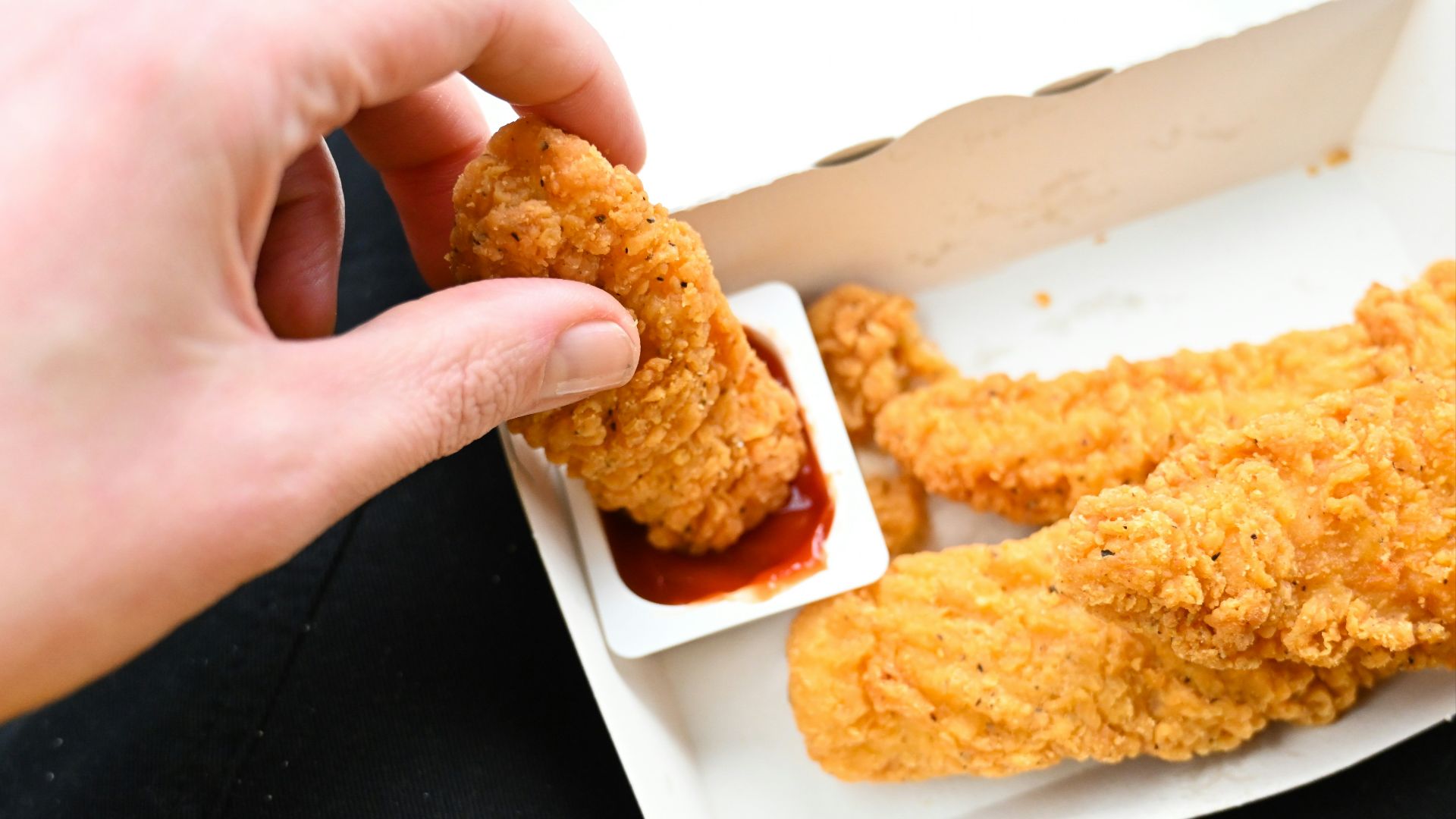 a person is dipping something into a container