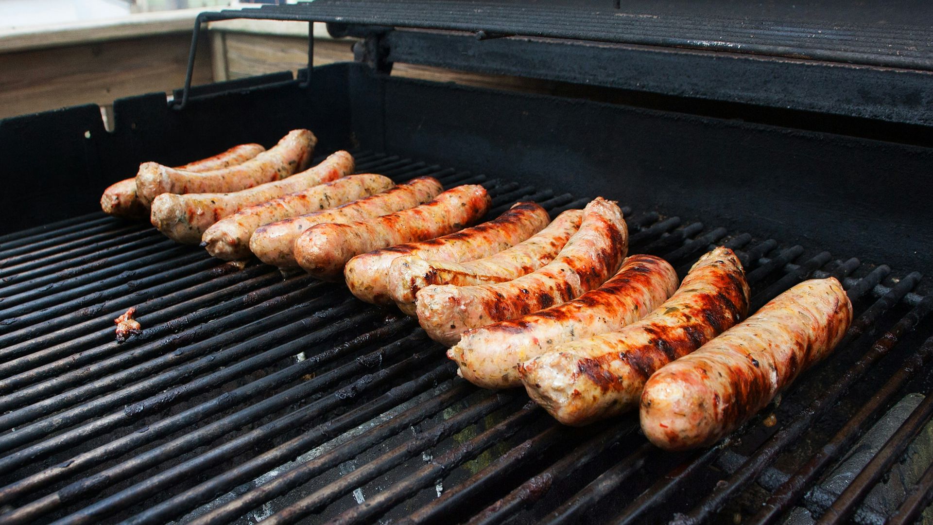 a bunch of sausages are cooking on a grill