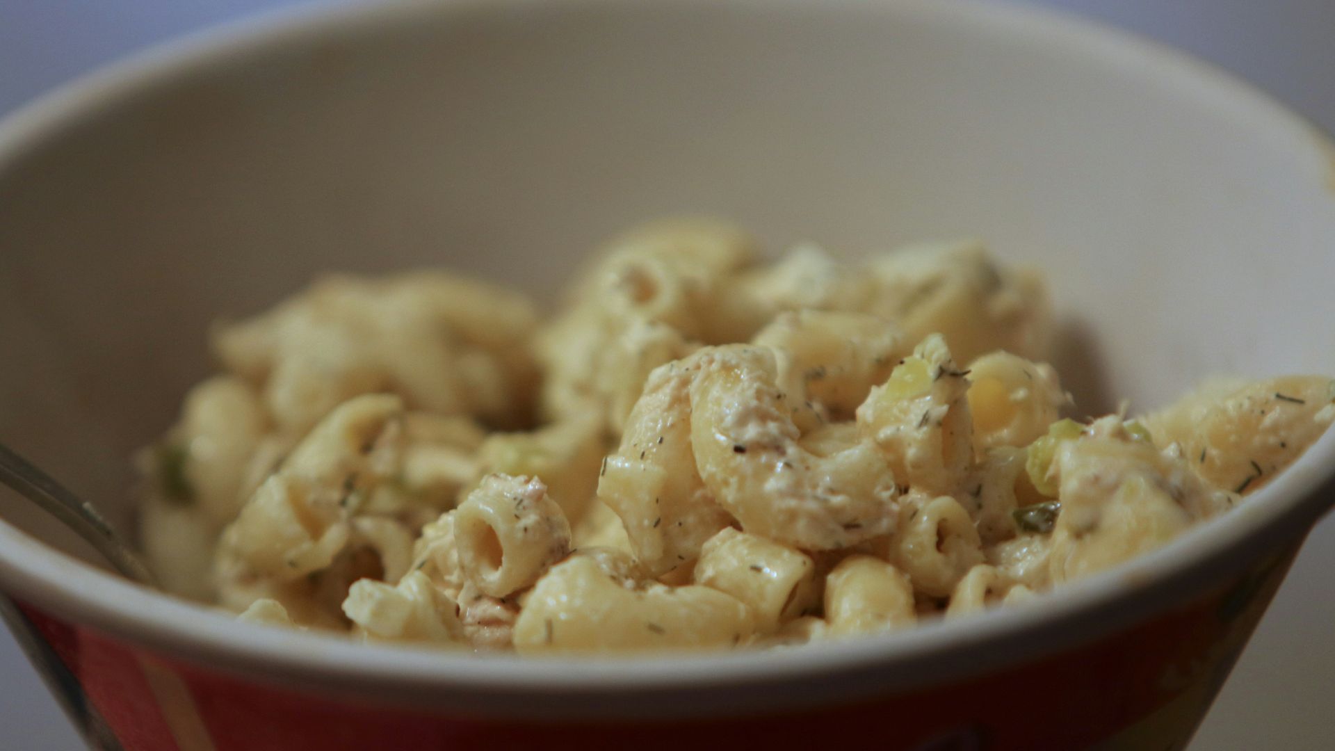 a bowl of macaroni and cheese with a spoon in it