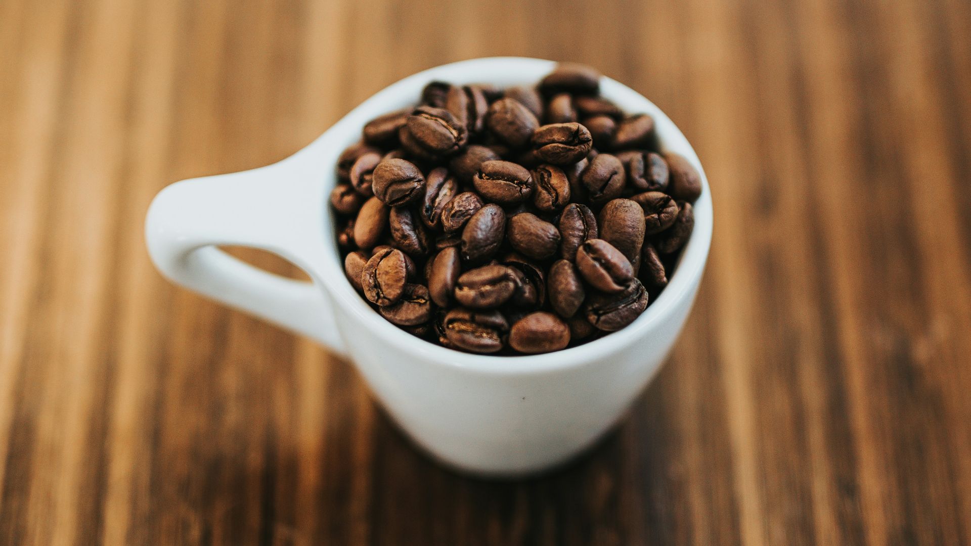 round white ceramic mug with coffee beans