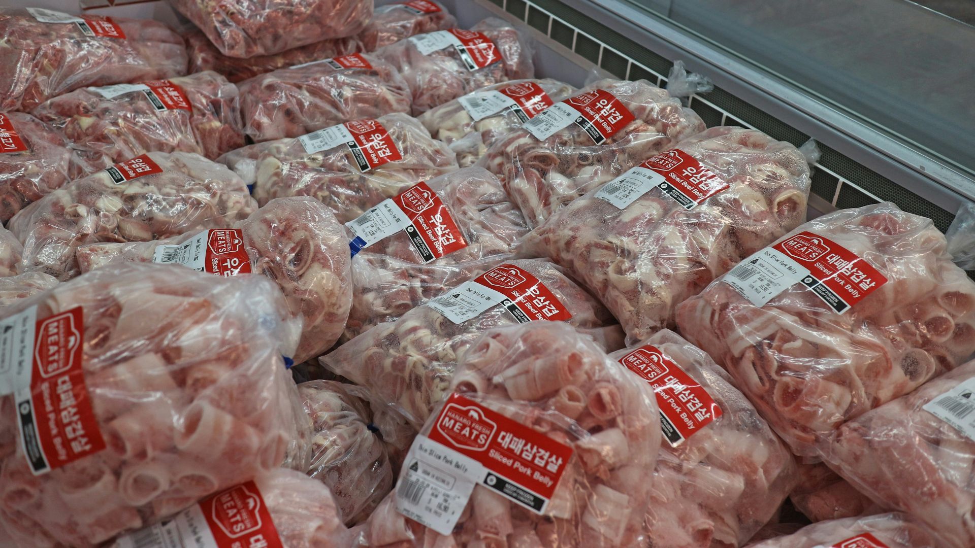 a pile of meat wrapped in plastic in a grocery store