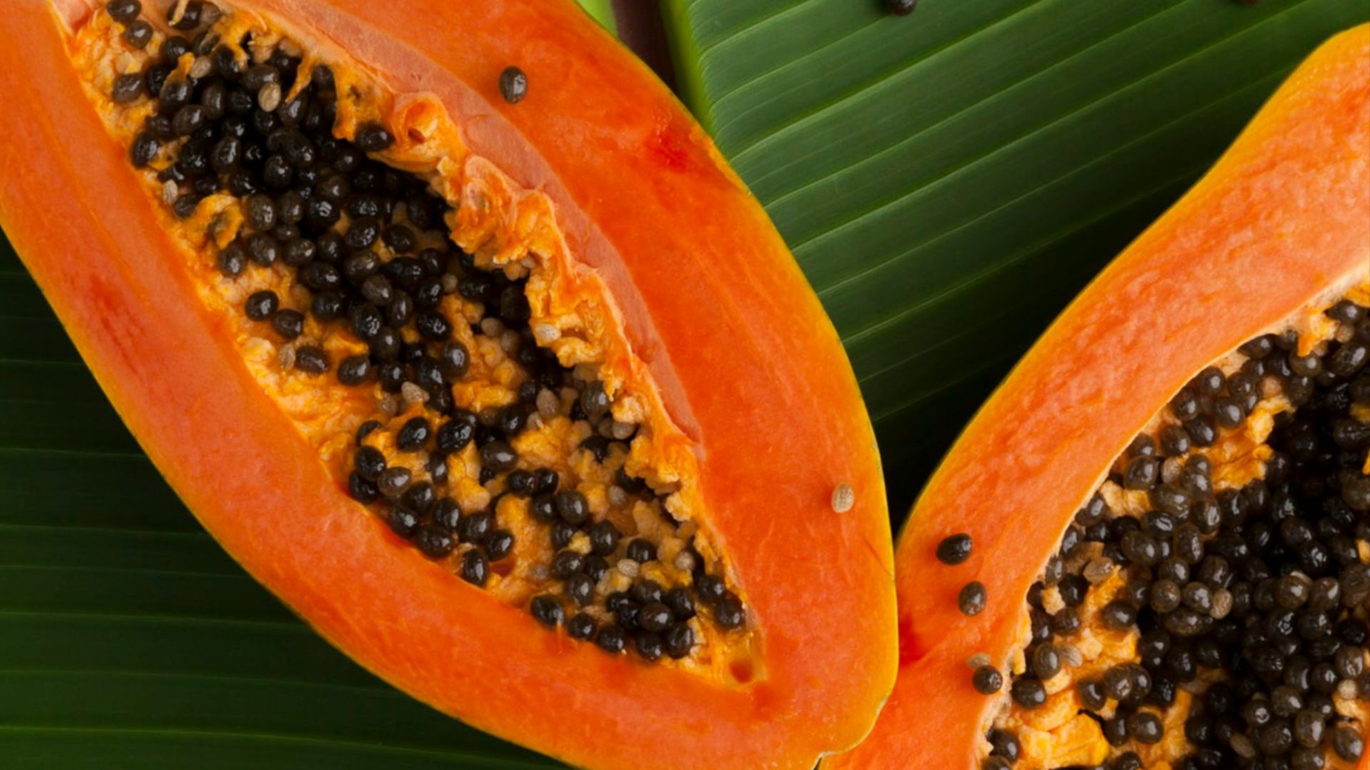 sliced papaya on green banana leaf