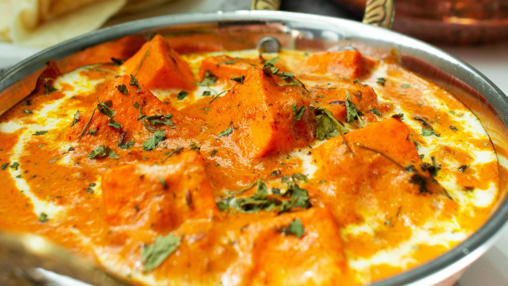 a metal bowl filled with food next to a bowl of rice