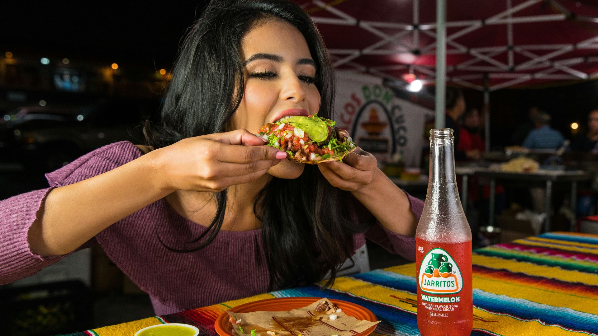 woman in purple shirt holding green and yellow floral ceramic bowl