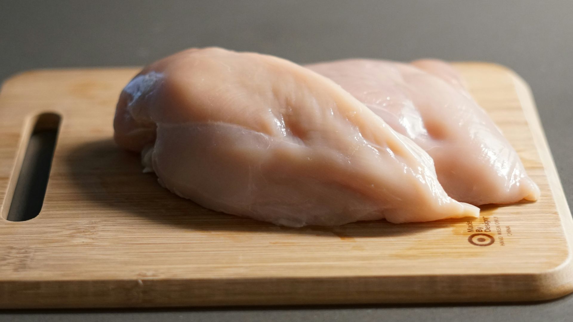 a piece of raw chicken on a cutting board
