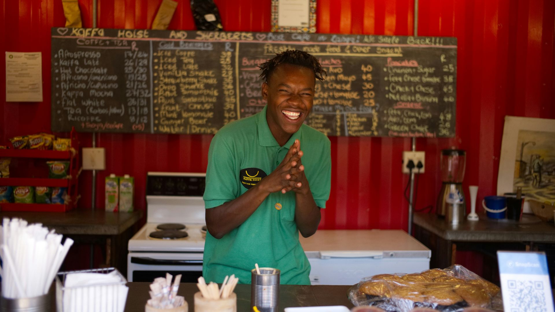 man in green crew neck t-shirt holding brown leather bag