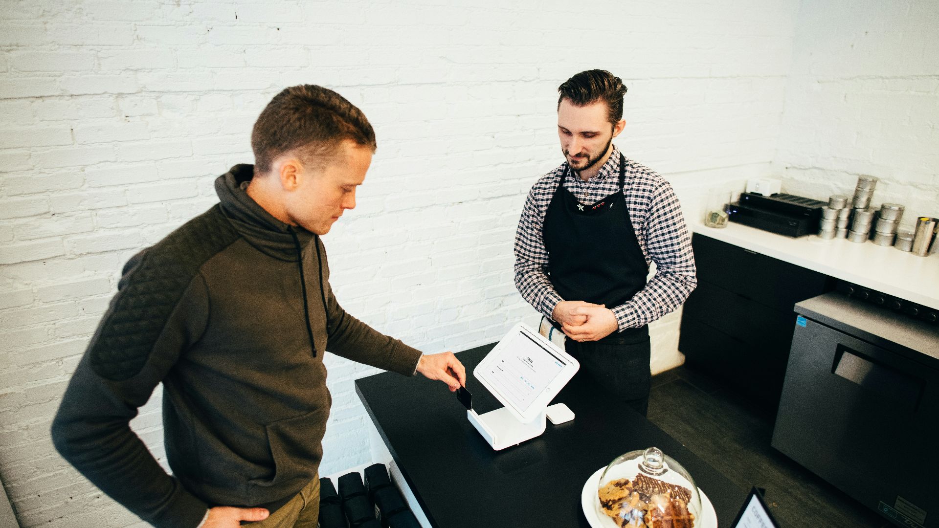 man looking at white digital device