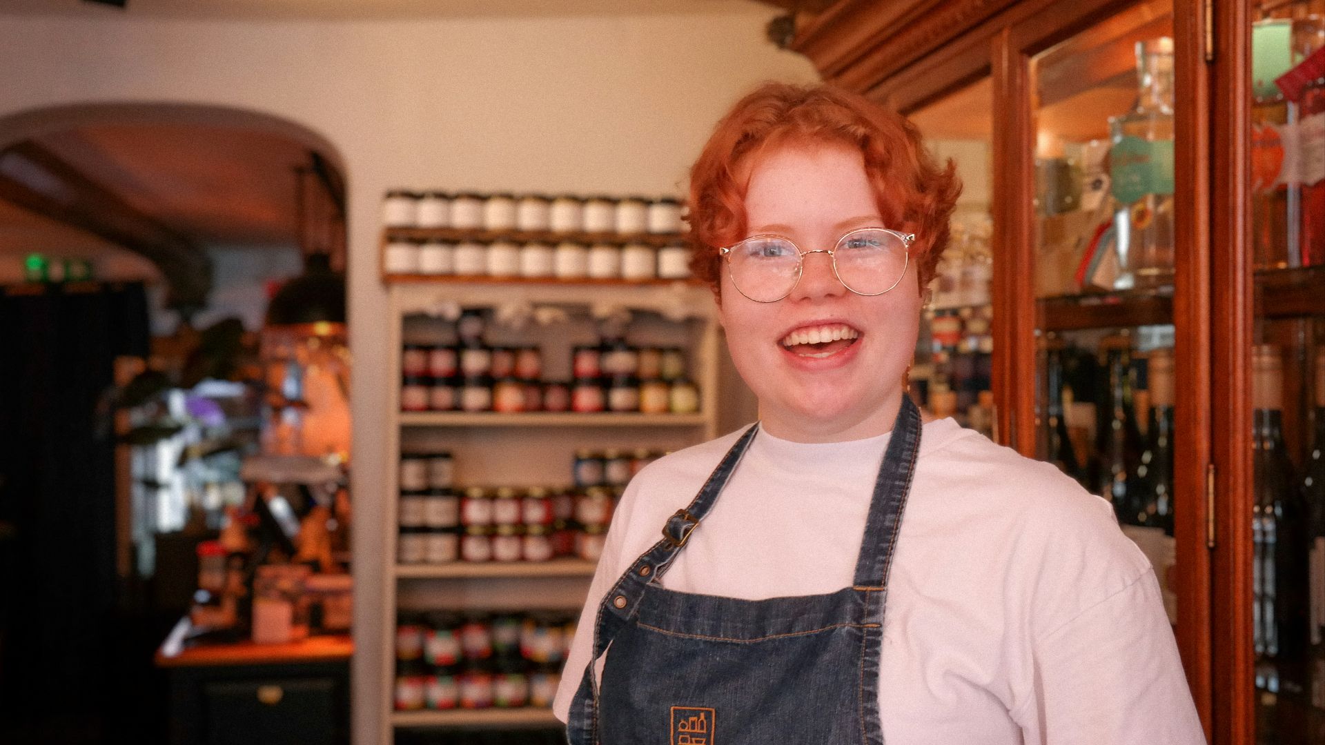 a woman wearing glasses and an apron in a store