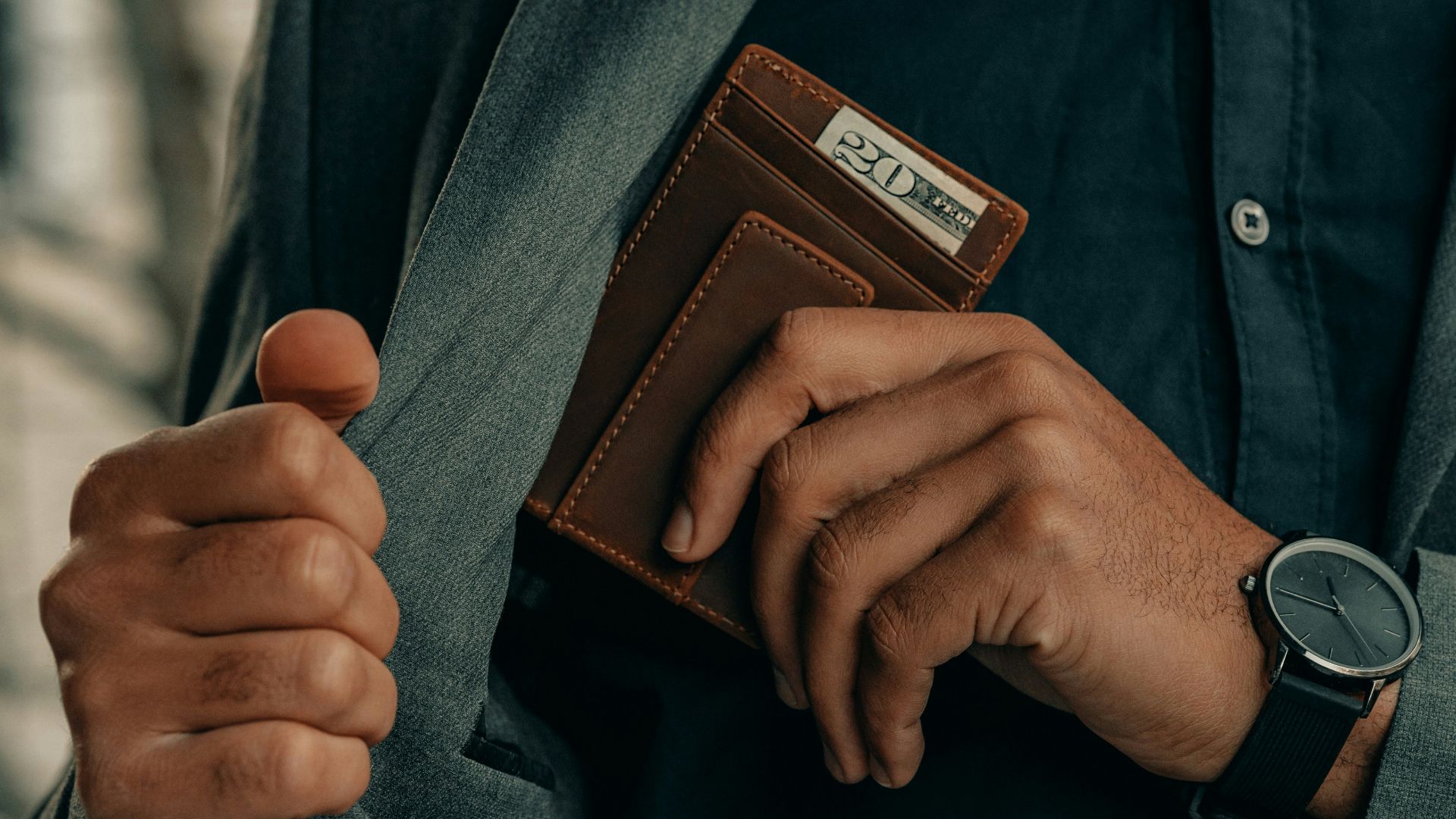 a man holding a wallet and a watch
