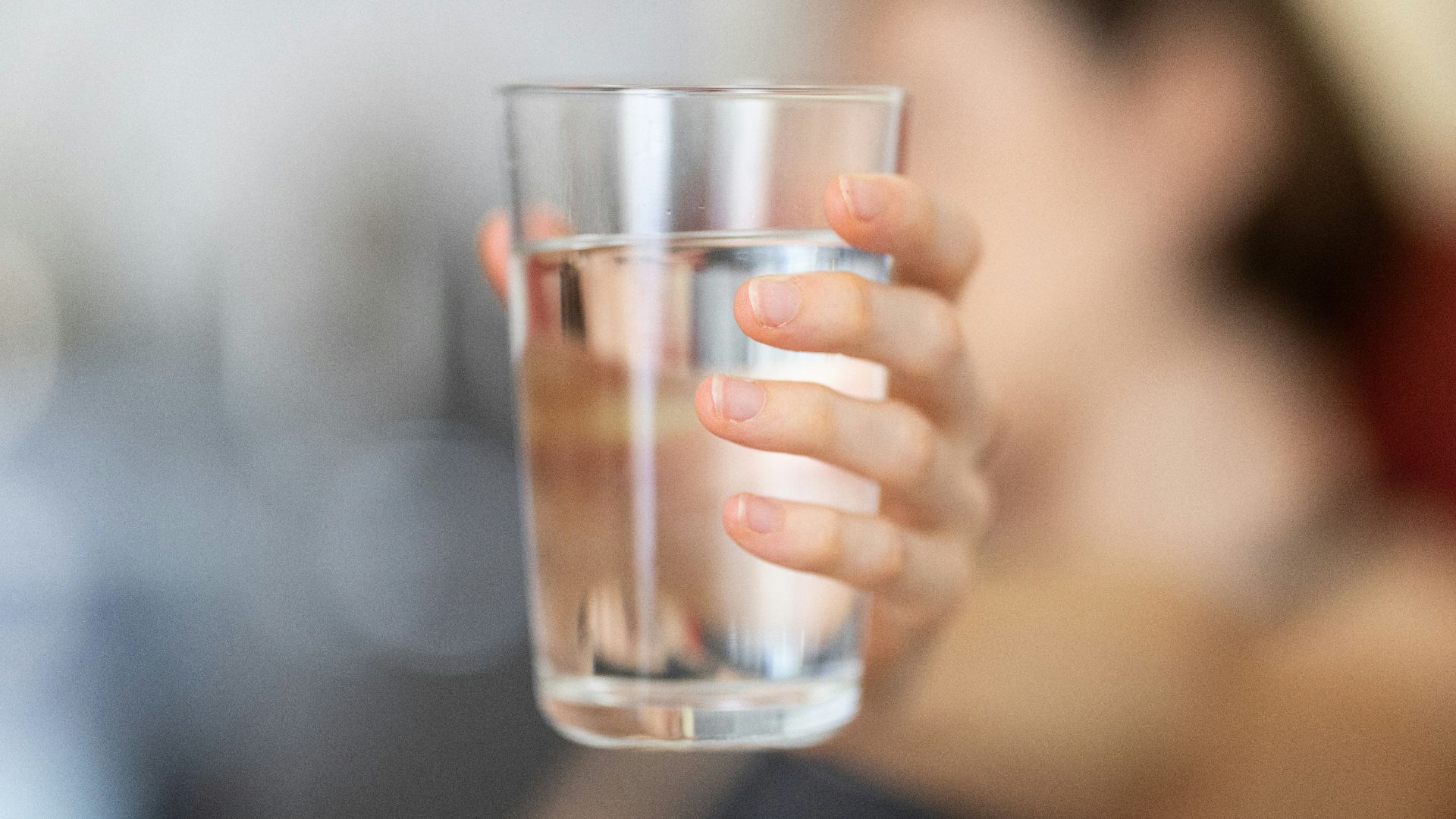 person holding clear drinking glass