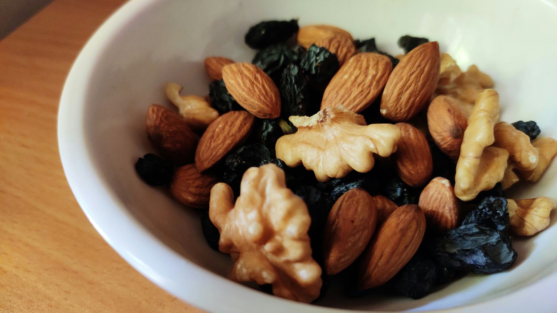 brown and black nuts on white ceramic bowl