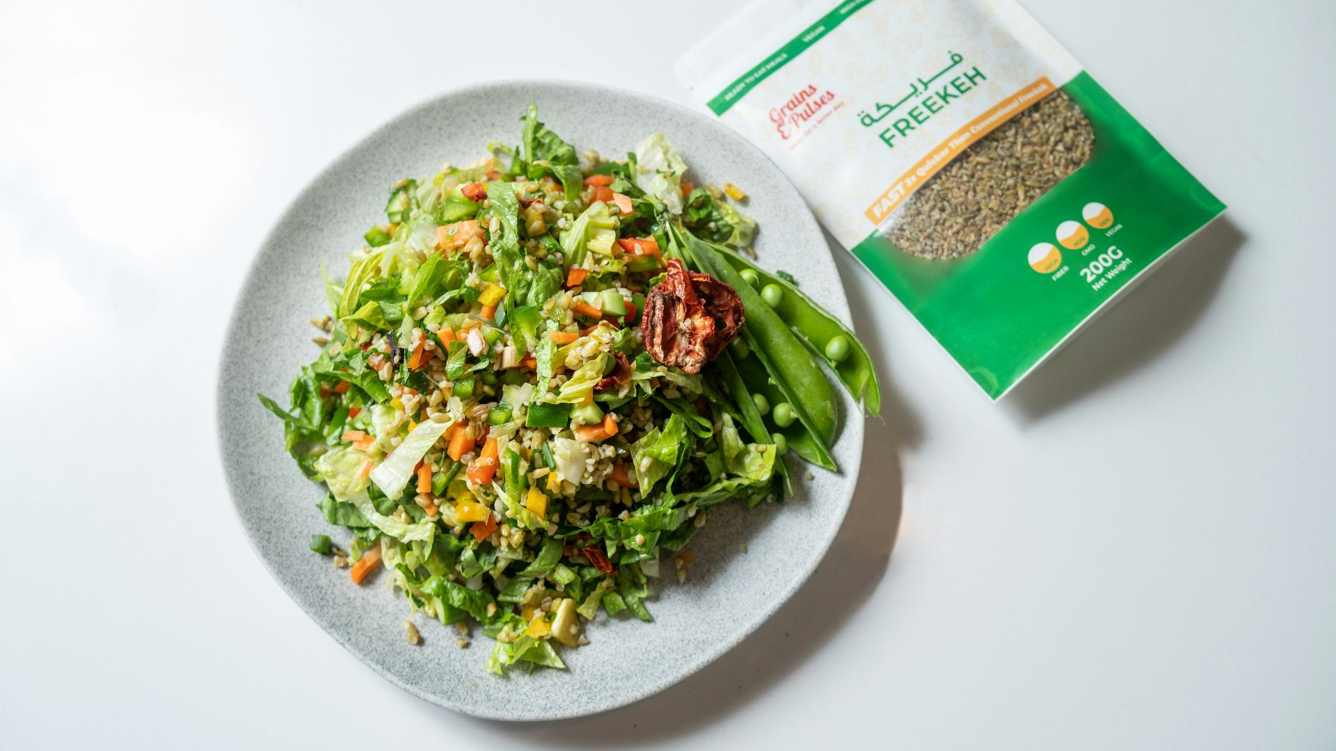 a white plate topped with a salad next to a bag of seeds