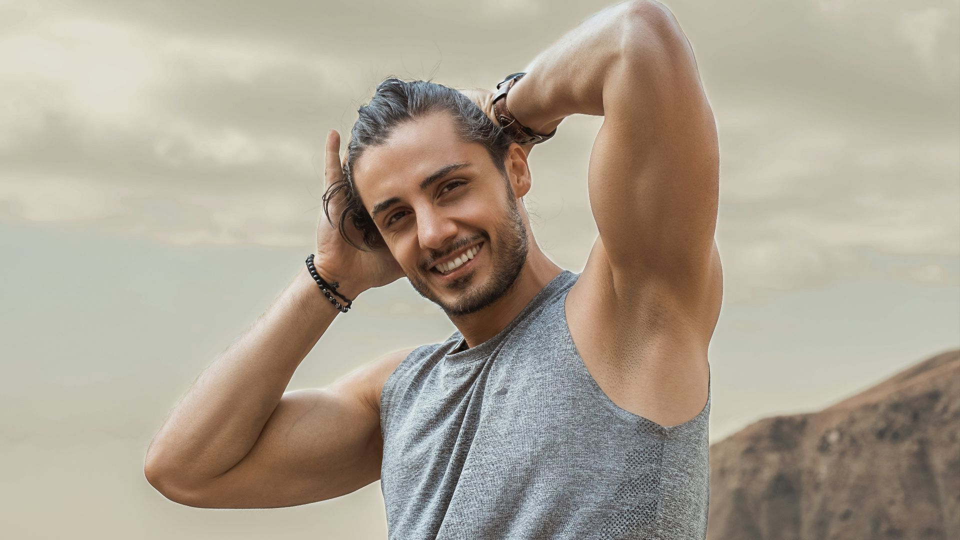 man in gray tank top smiling