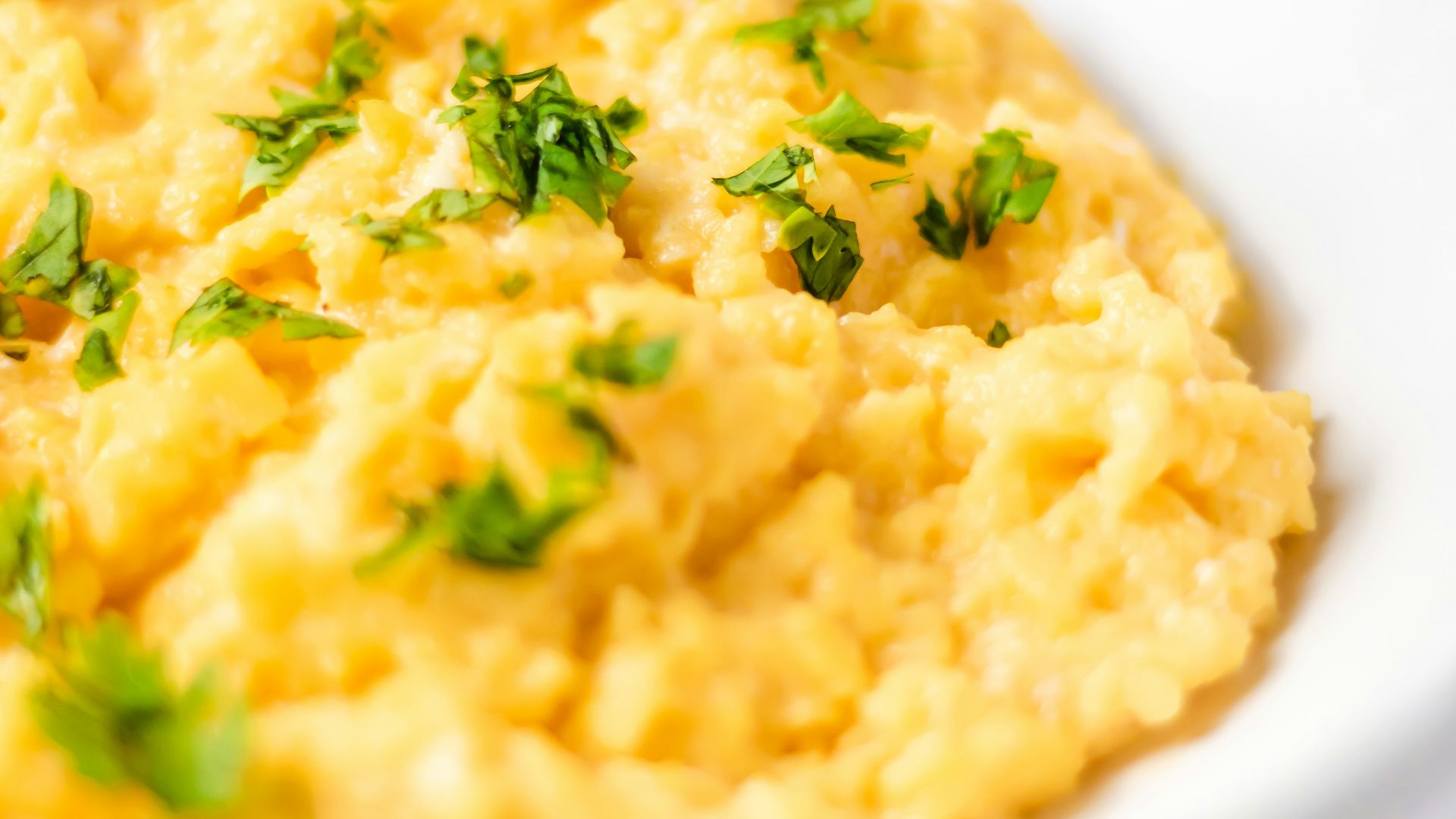 a bowl of mashed potatoes with parsley on top