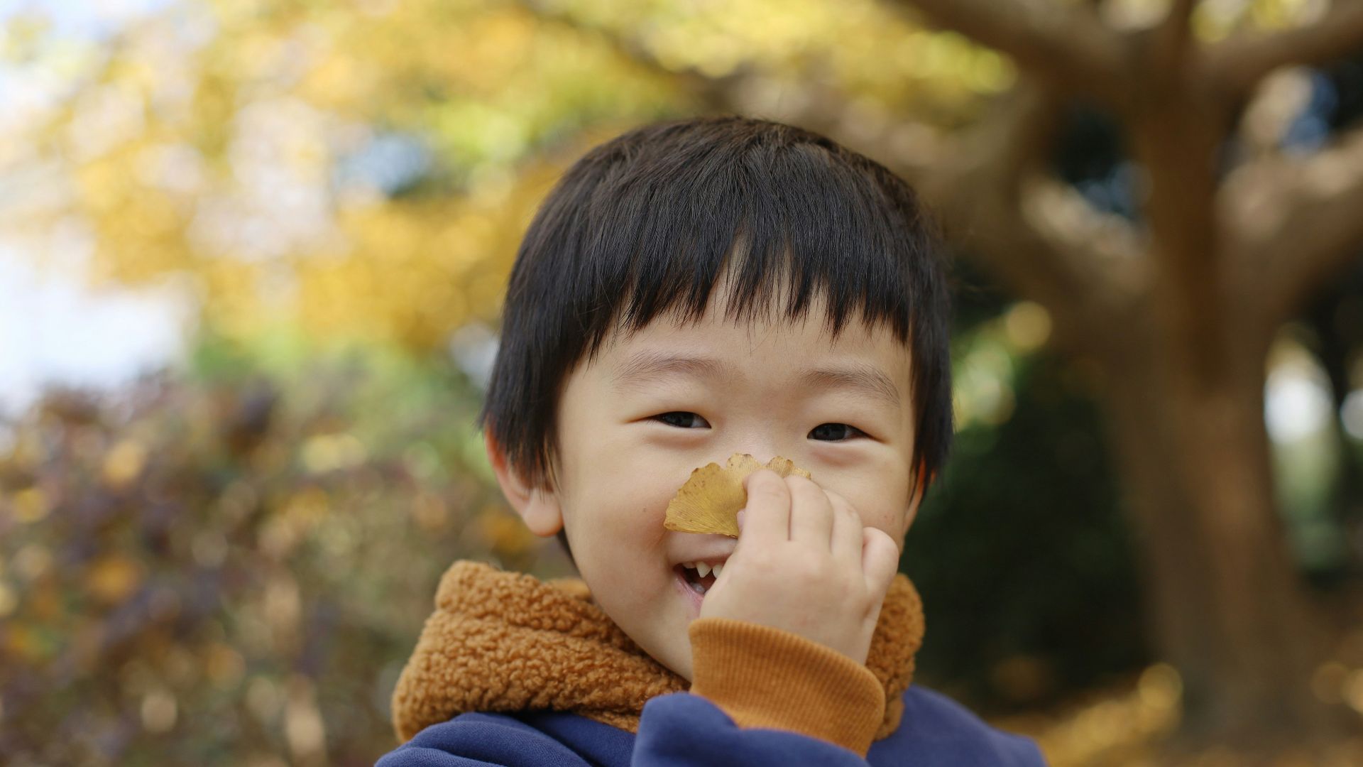 a young boy with a piece of food in his mouth