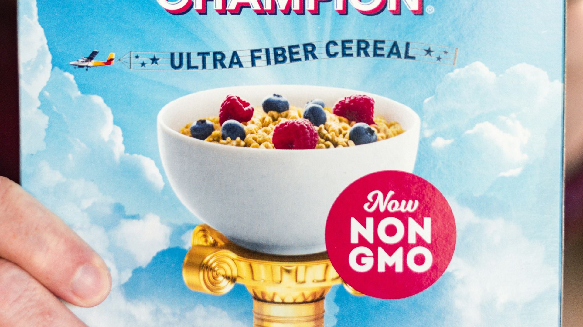 a woman holding up a box of cereal