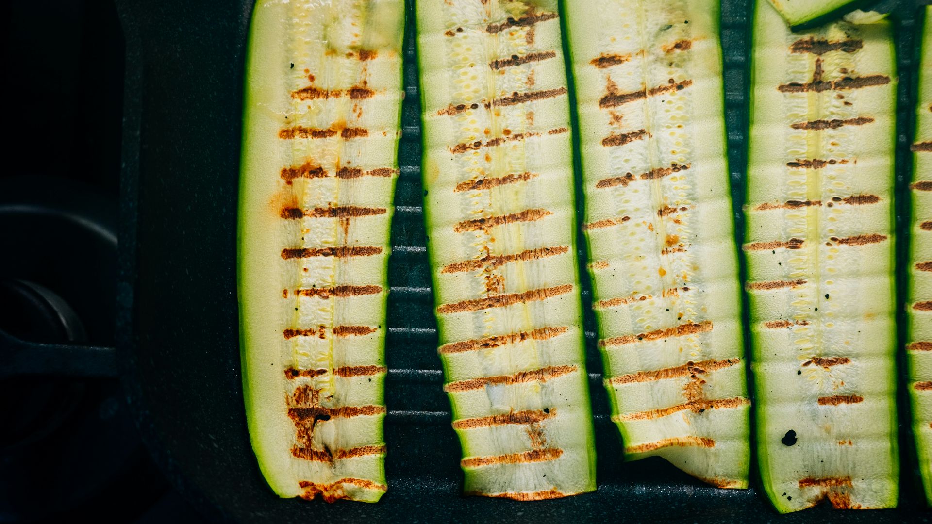 Grilled zucchini slices in a pan.