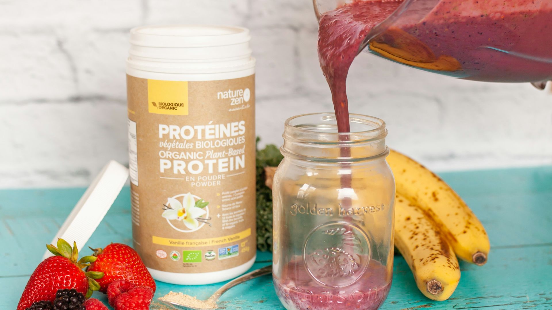 a person pouring a smoothie into a jar