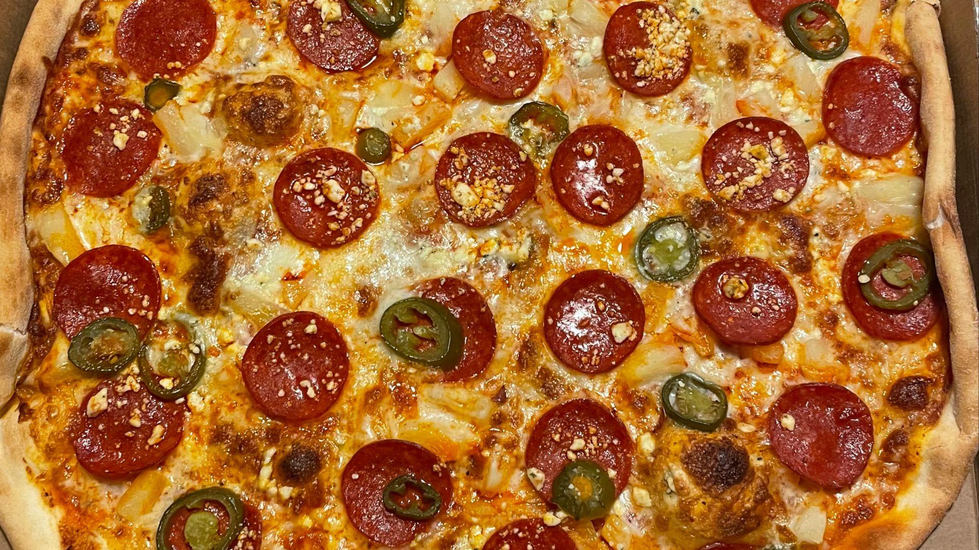 a large pepperoni pizza in a box on a table