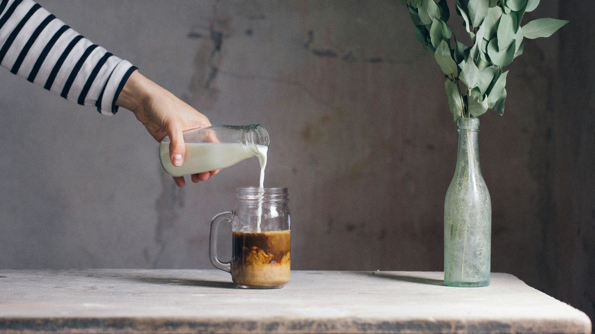 person filling milk on glass