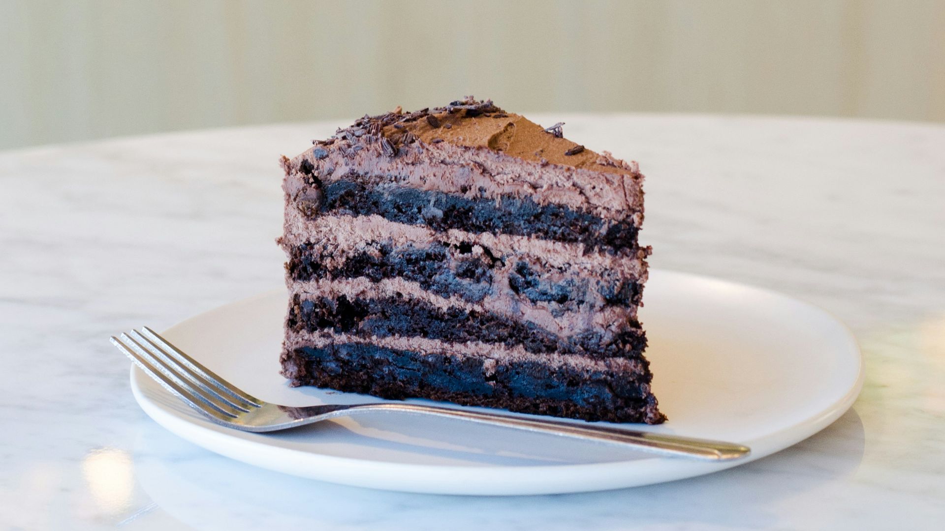 sliced chocolate cake beside fork on plate