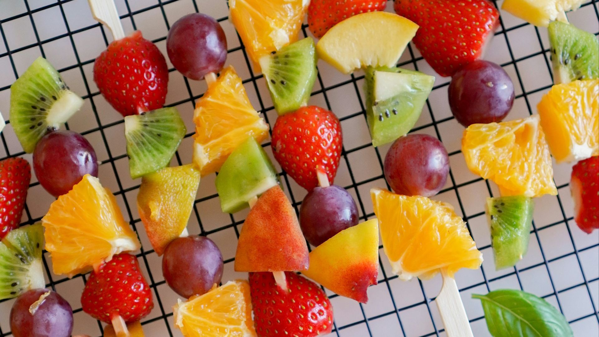 sliced strawberries and bananas on pink plastic plate