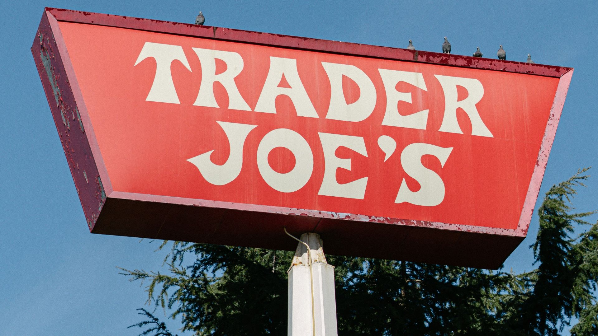 A red trader joe's sign on top of a pole