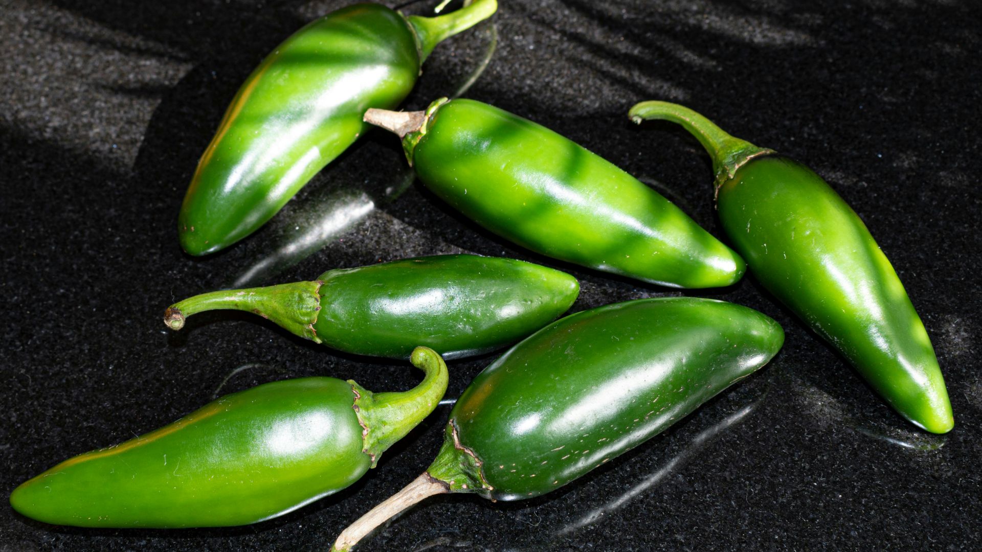 a group of green peppers sitting on top of a counter