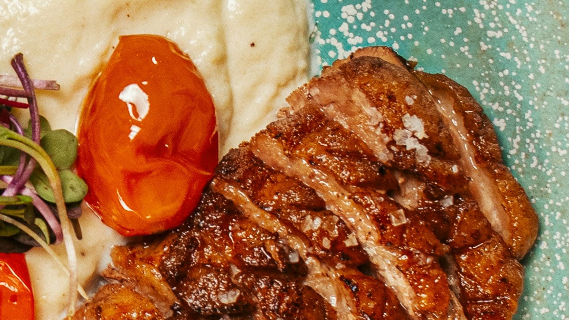 A blue plate topped with meat and vegetables
