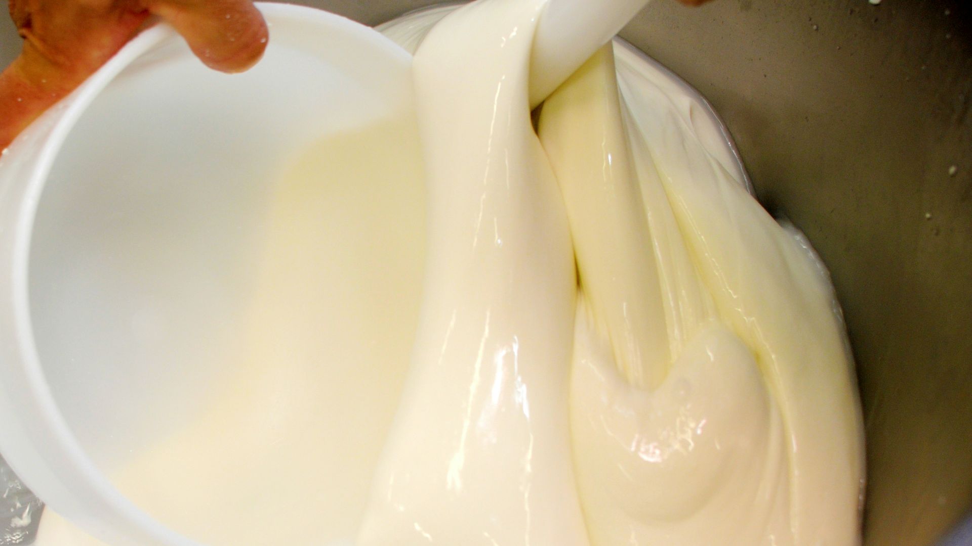 a mixing bowl filled with a mixture of cream