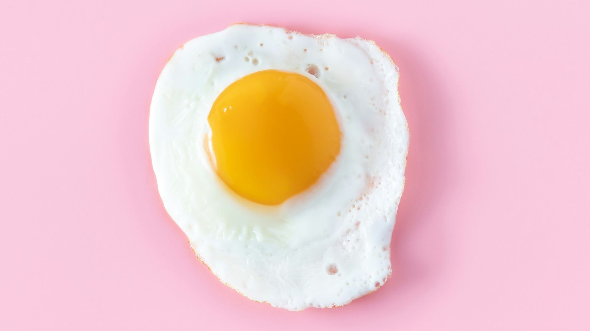 sunny side up egg on pink surface