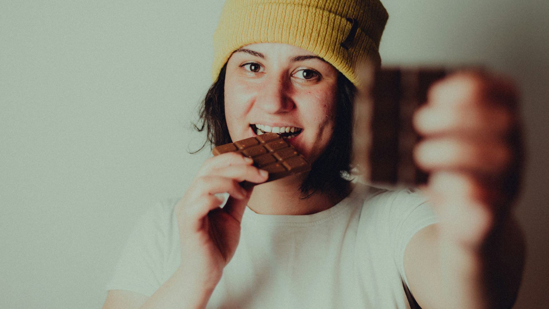 woman in white crew neck t-shirt wearing yellow knit cap