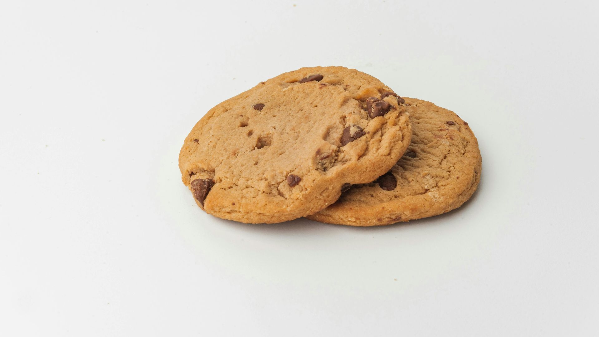 Two chocolate chip cookies on a white plate