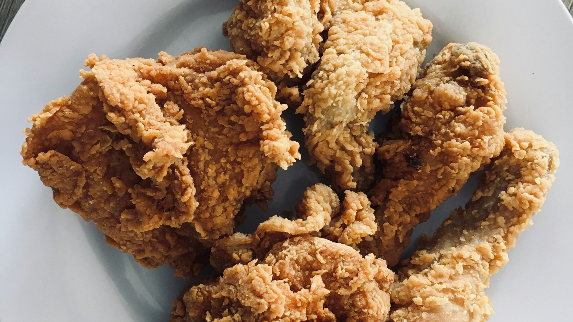 a white plate topped with fried food on top of a wooden table