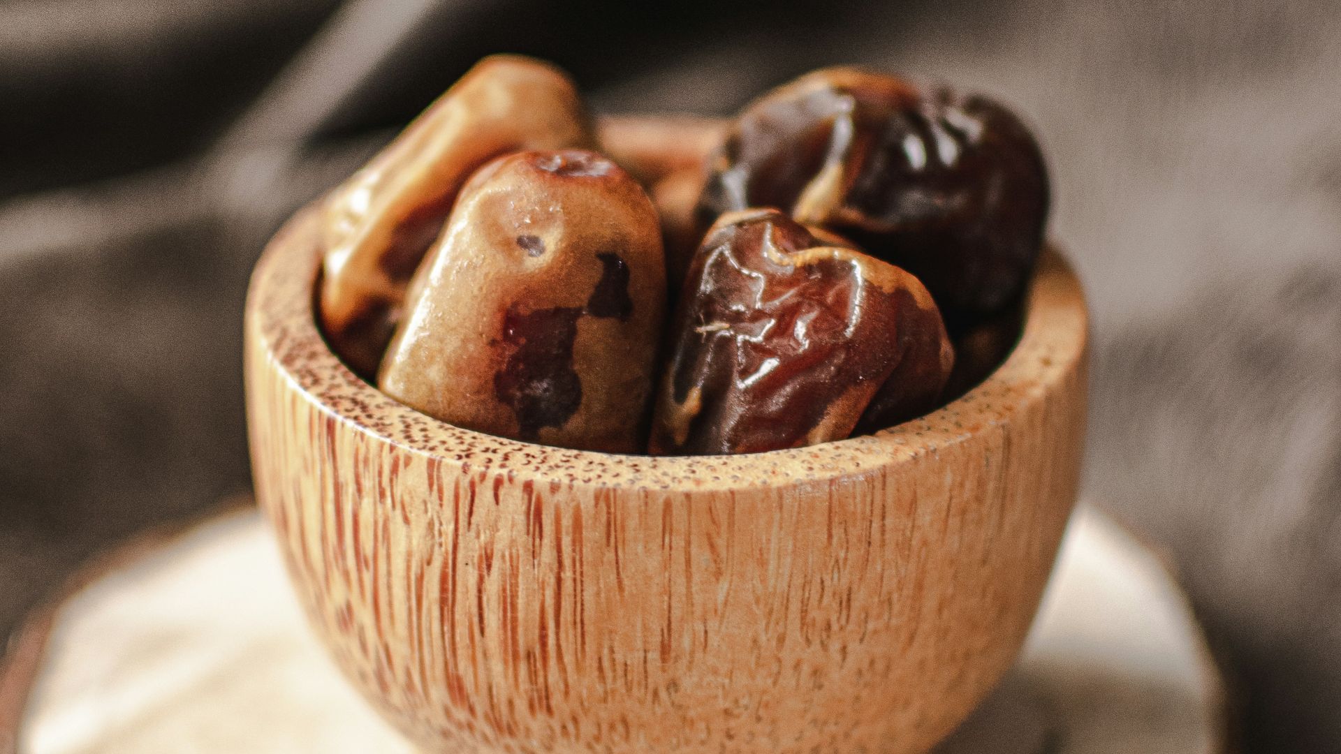 a wooden bowl filled with nuts on top of a wooden plate