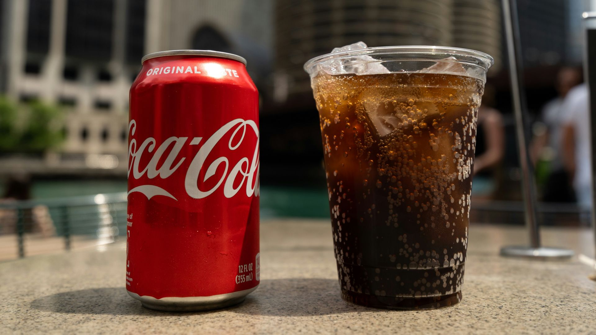 Coca-Cola soda tin can and cup on table close-up photography