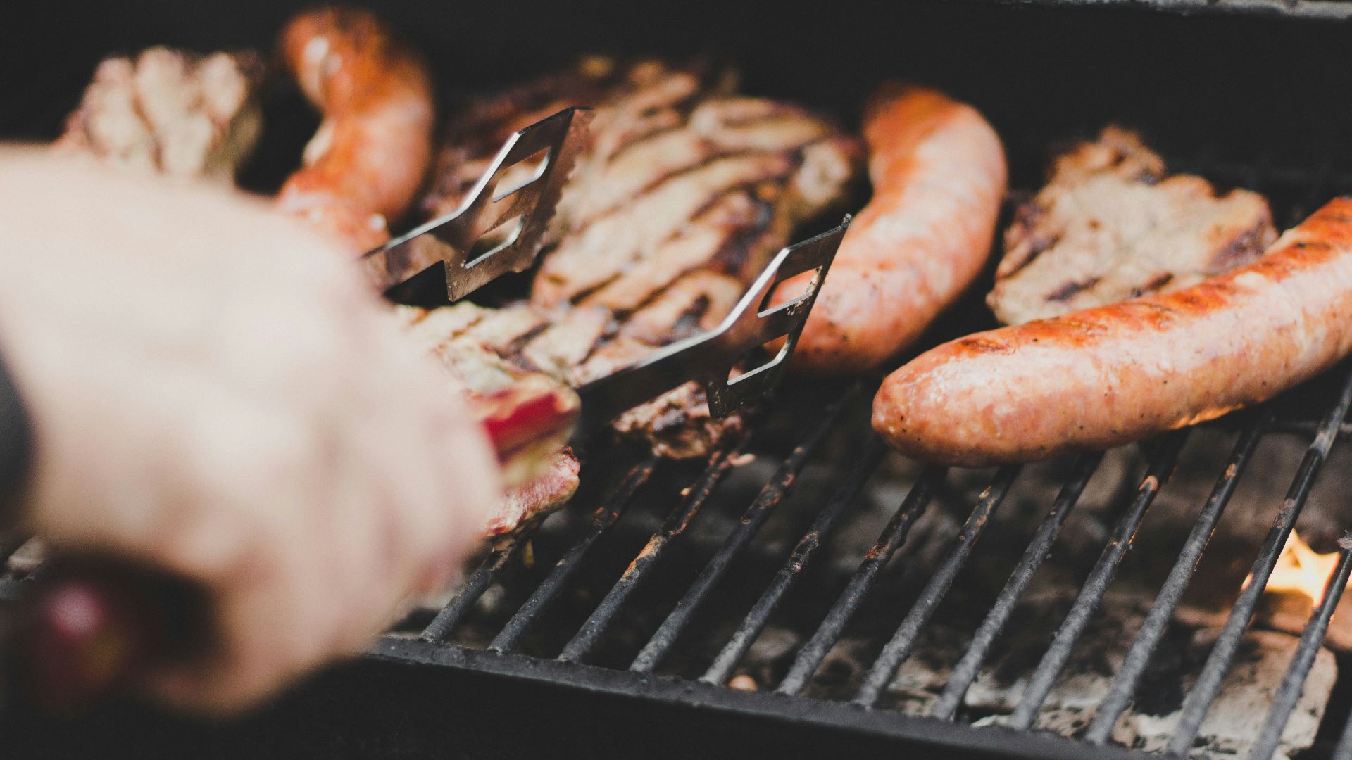 person grilling sausage and meat
