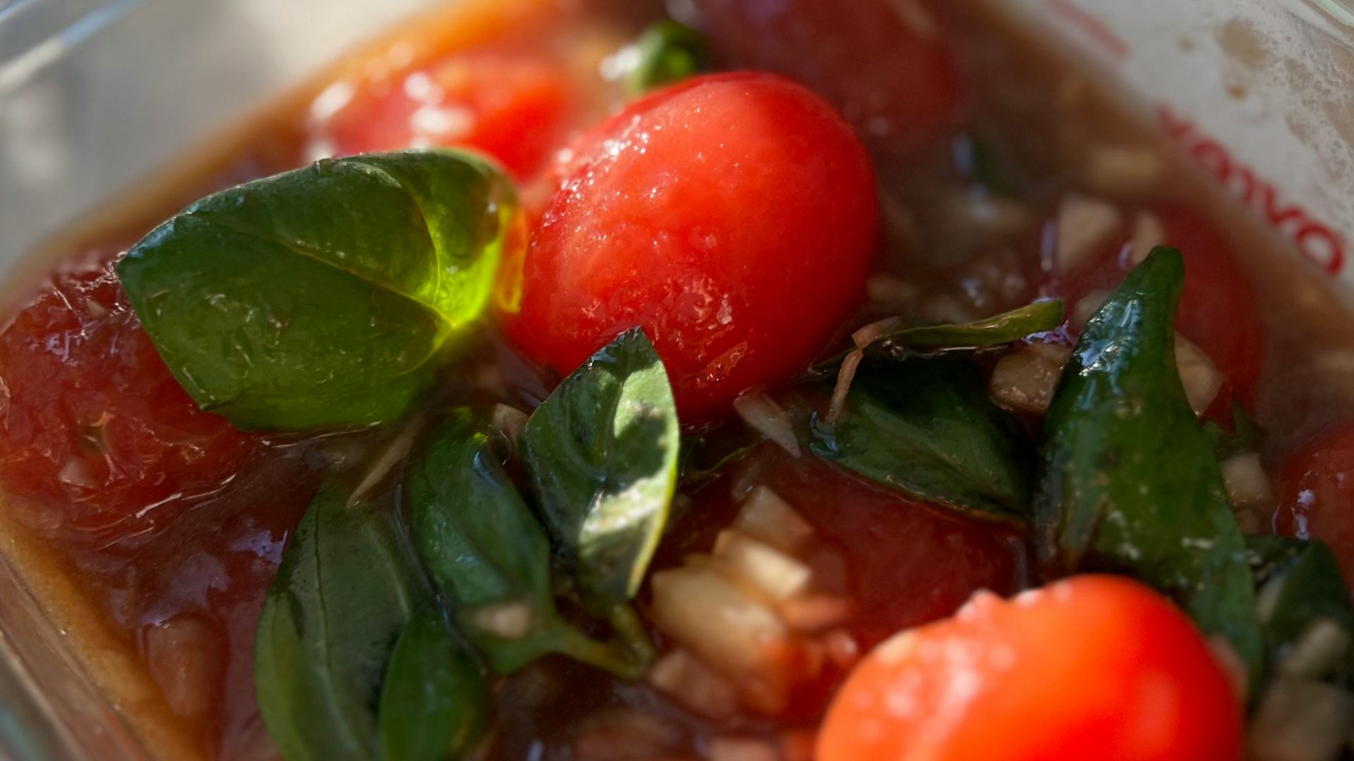 a plastic container filled with tomatoes and other vegetables
