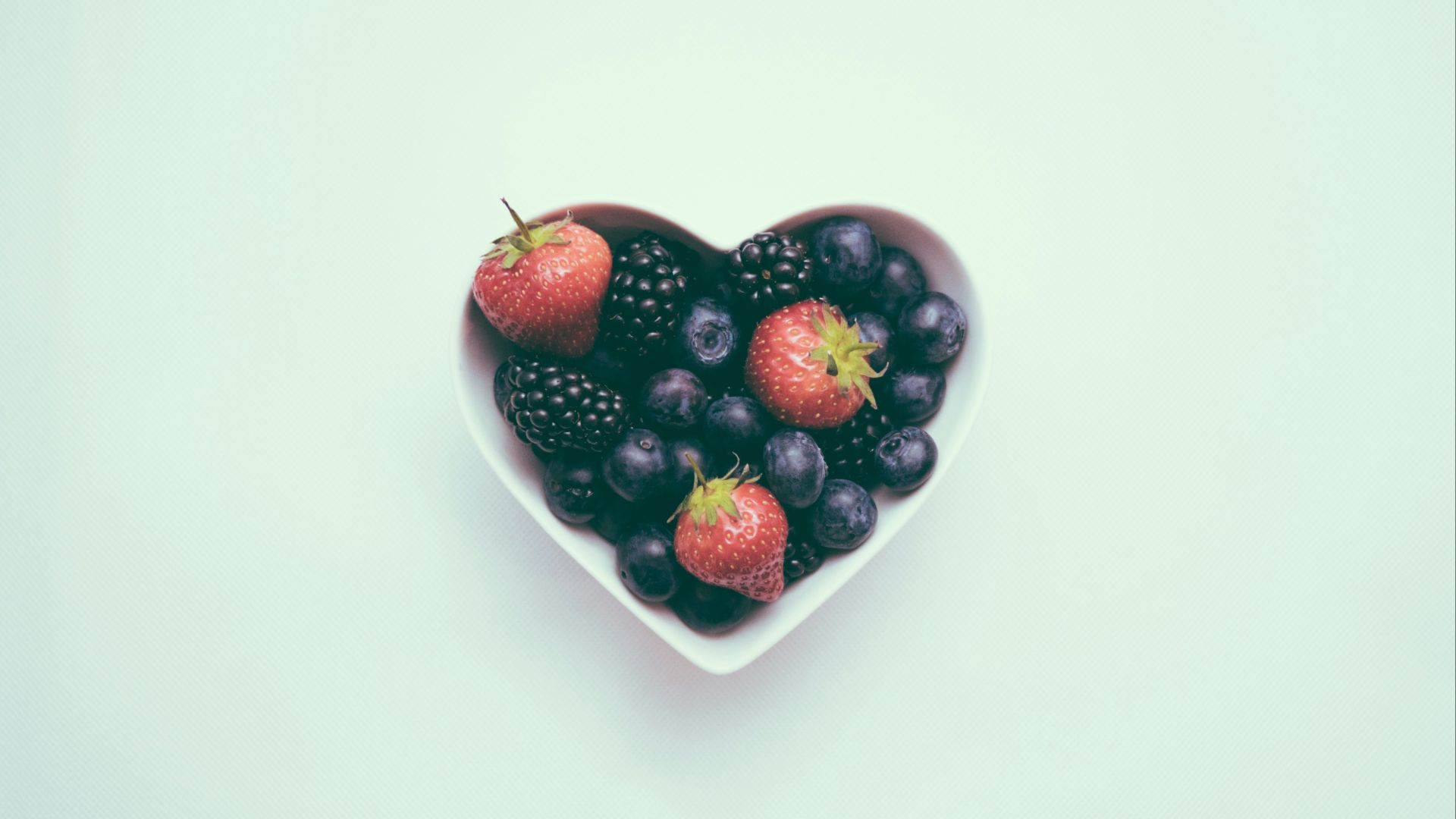 heart-shaped bowl with strawberries