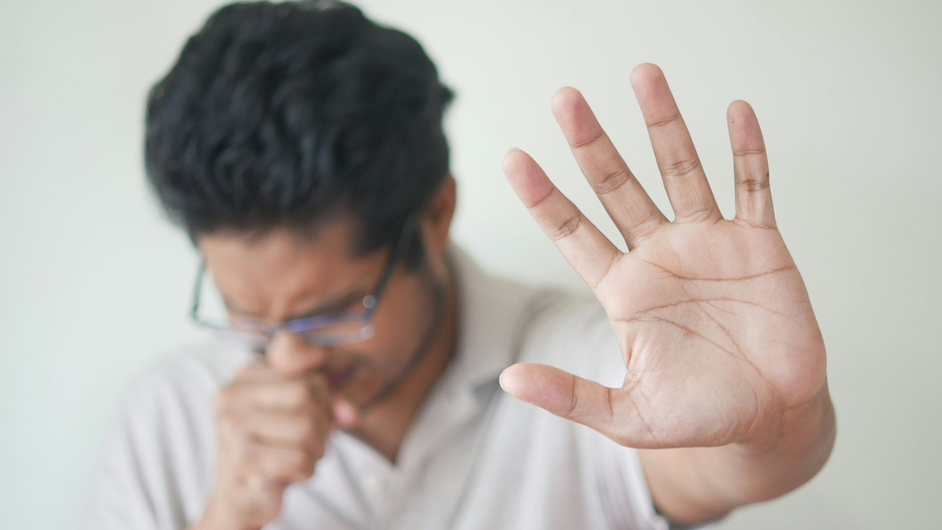 a man holding his hand up in front of his face