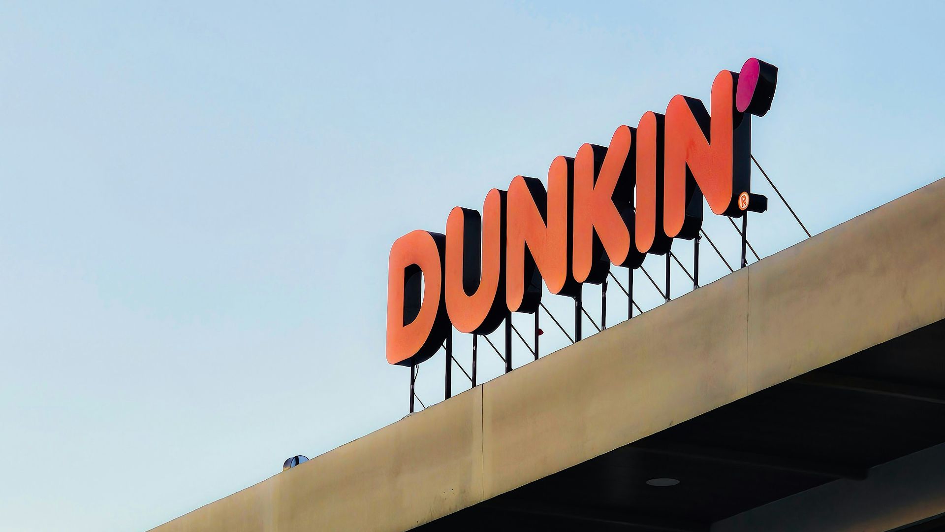 a dunkin'donuts sign on top of a building